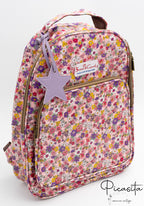 Mochila escolar con estampado de flores rosas y lilas con charm de estrella morada.