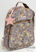 Mochila infantil azul con flores amarillas y charm rosa con nombre grabado.