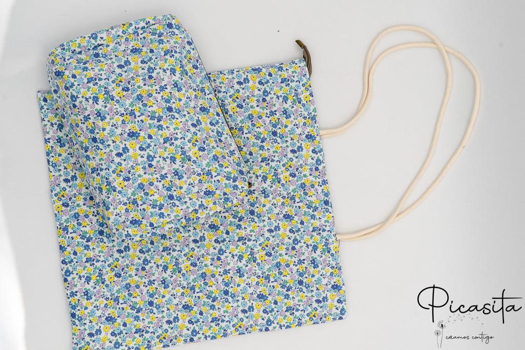 Conjunto de neceser y bolsa con diseño de flores pequeñas en color azul y amarillo.