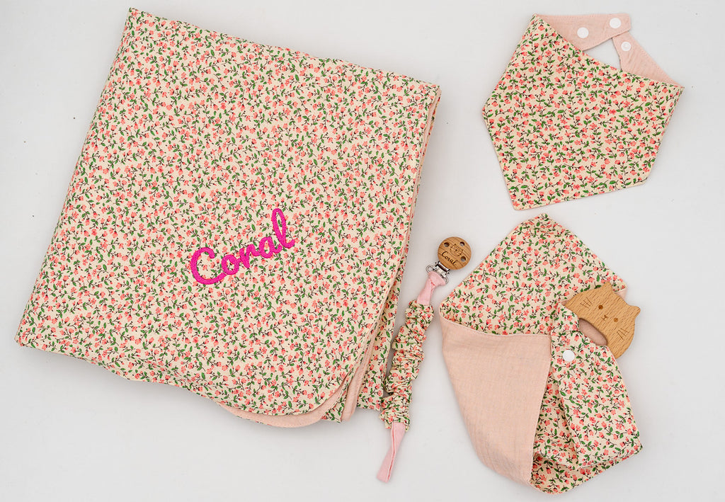 Rosa Set mit geblümter Decke und eingesticktem Namen Coral, Halstuch-Lätzchen, rosa Musselintuch mit Holz-Beißring und Schnullerkette.