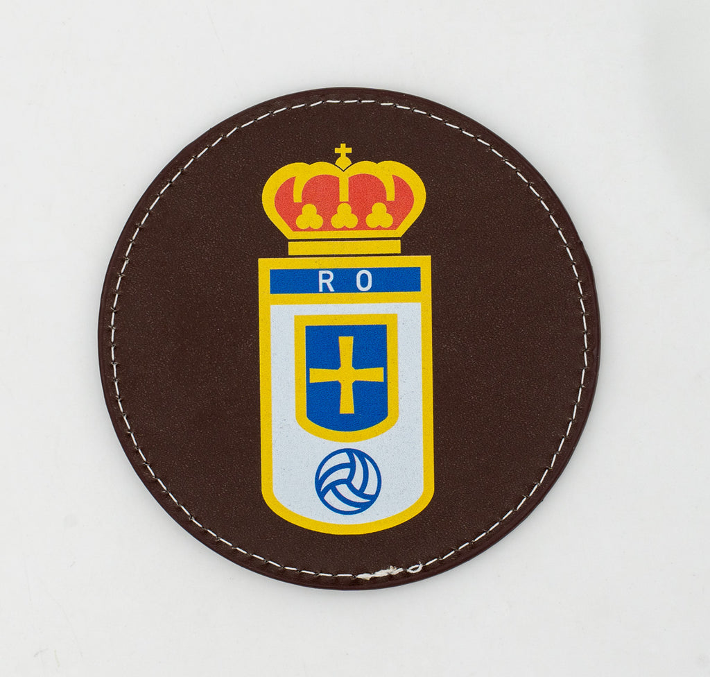 Runder brauner Untersetzer mit farbigem Fußballwappen.