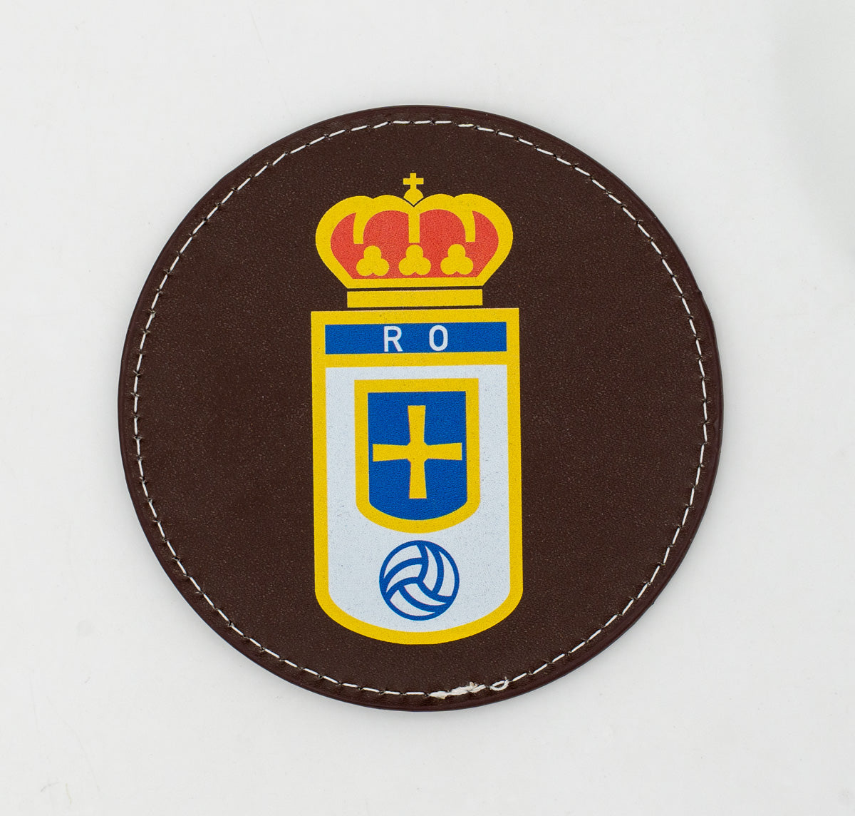 Runder brauner Untersetzer mit farbigem Fußballwappen.