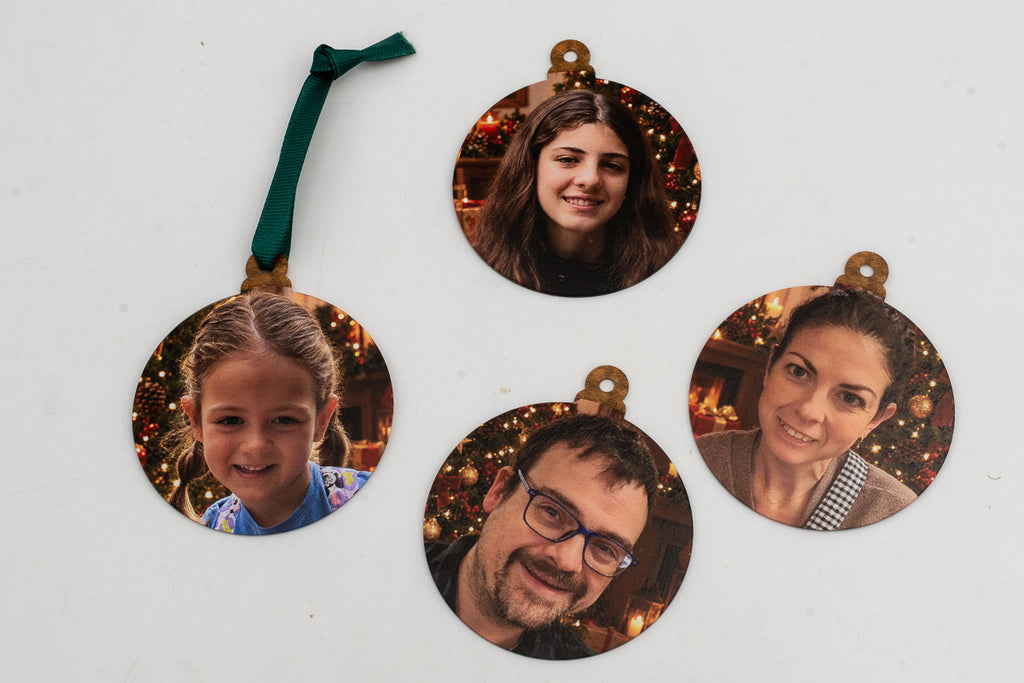 Vier flache Anhänger mit einzelnen Fotografien vor weihnachtlichem Hintergrund.