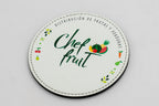 Runder weißer Untersetzer mit Chef-Fruit-Marke und farbigen Früchten.