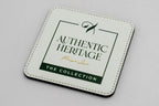 Quadratischer weißer Untersetzer mit grünem Authentic-Heritage-Logo.
