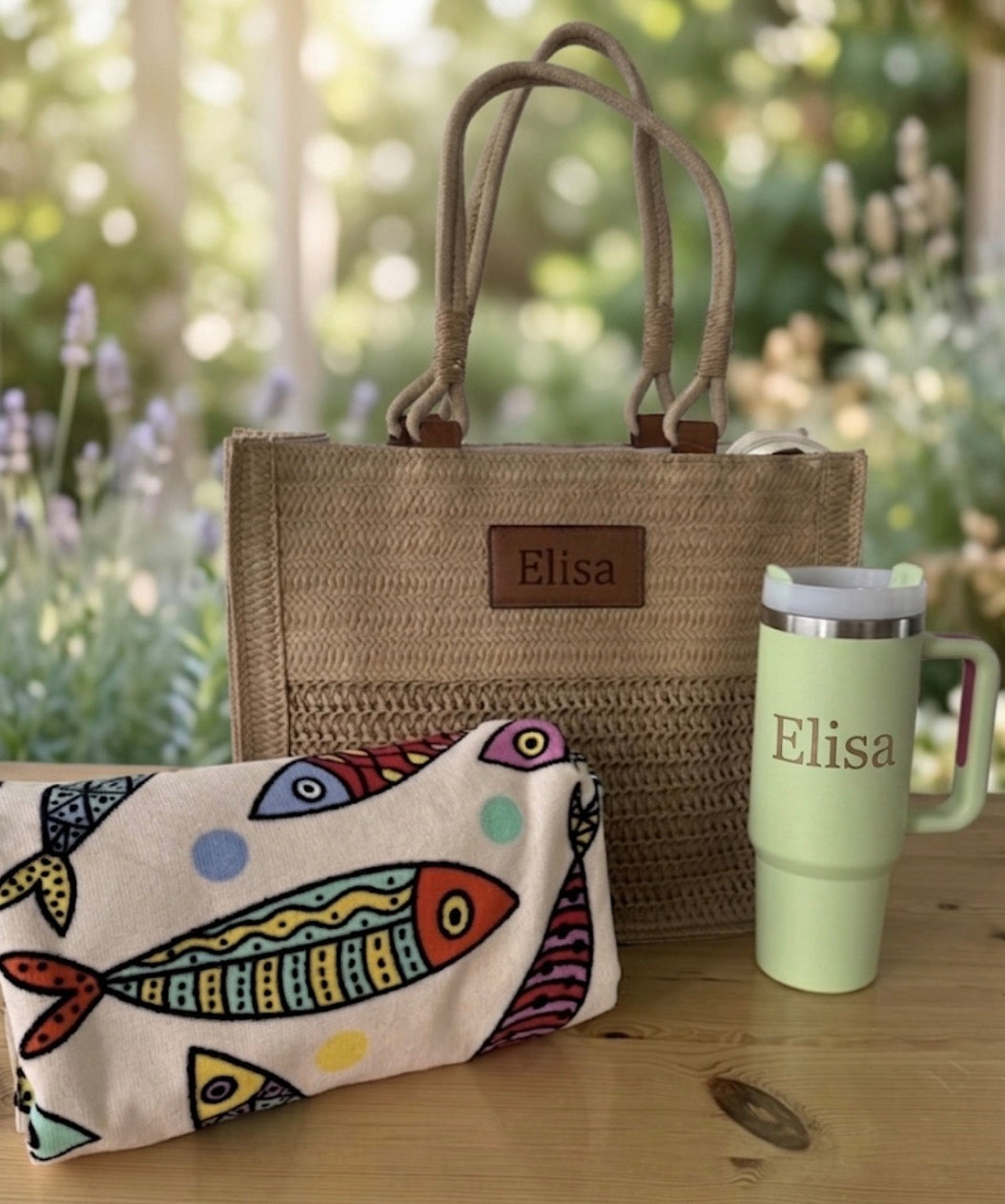Bolso de rafia natural con parche personalizado Elisa y toalla crema con peces de colores.