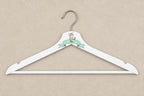 Percha adulta blanca con gatito, cinta menta y nombre Mía sobre mesa beige