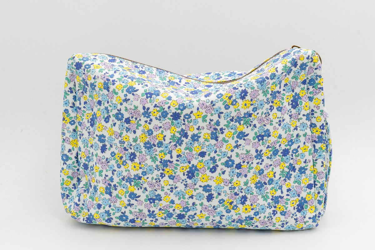 Stoff-Kulturbeutel mit blauen und gelben Blumen, Vorderansicht auf neutralem Hintergrund