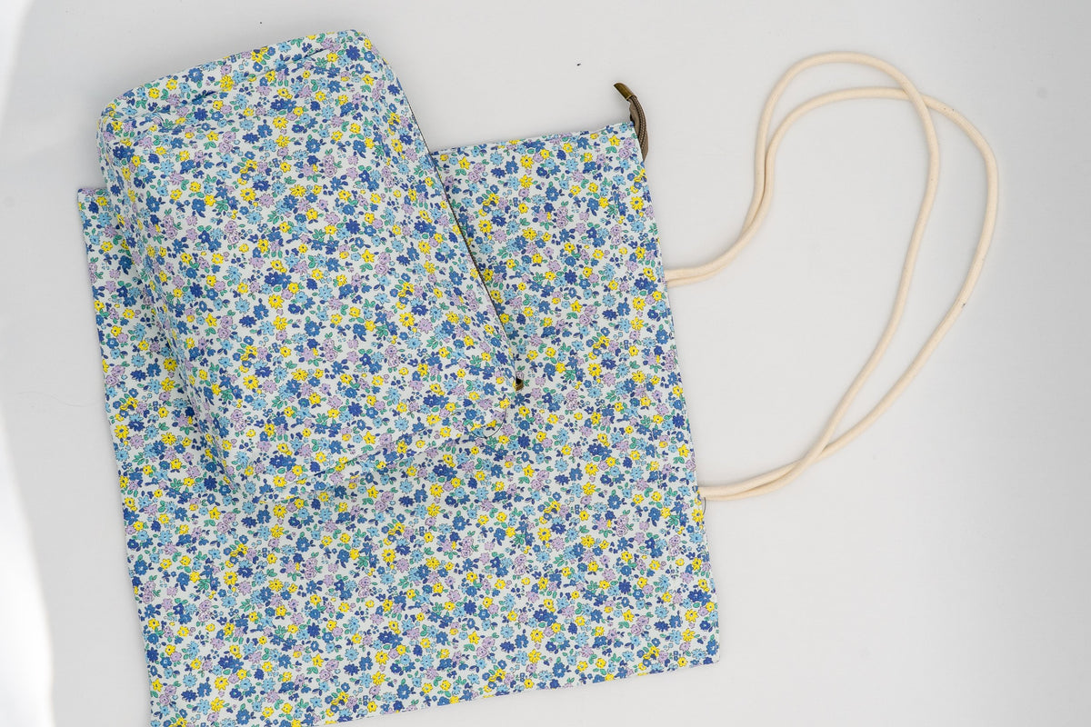 Set aus Kosmetiktasche und Beutel mit kleinen blauen und gelben Blumen.