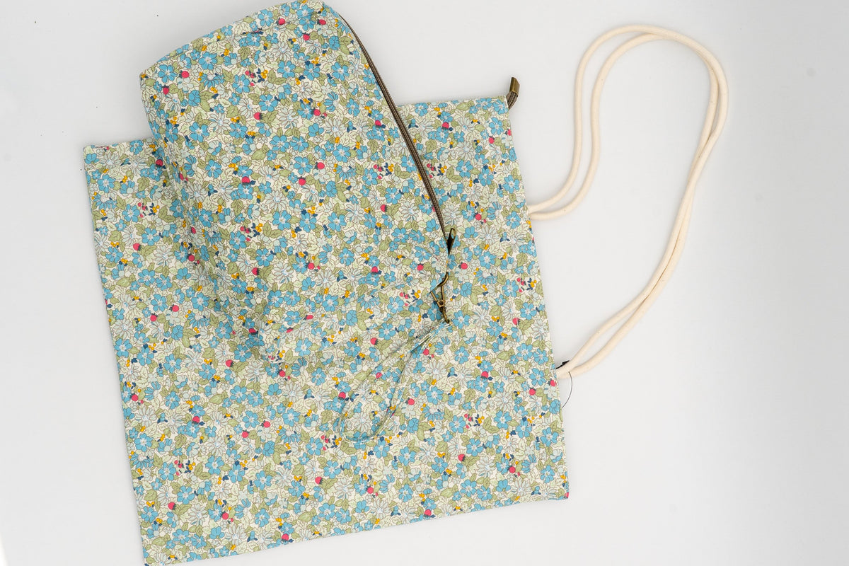 Beutel und Kosmetiktasche mit grünem Blumenmuster auf weißem, strapazierfähigem Baumwollstoff.
