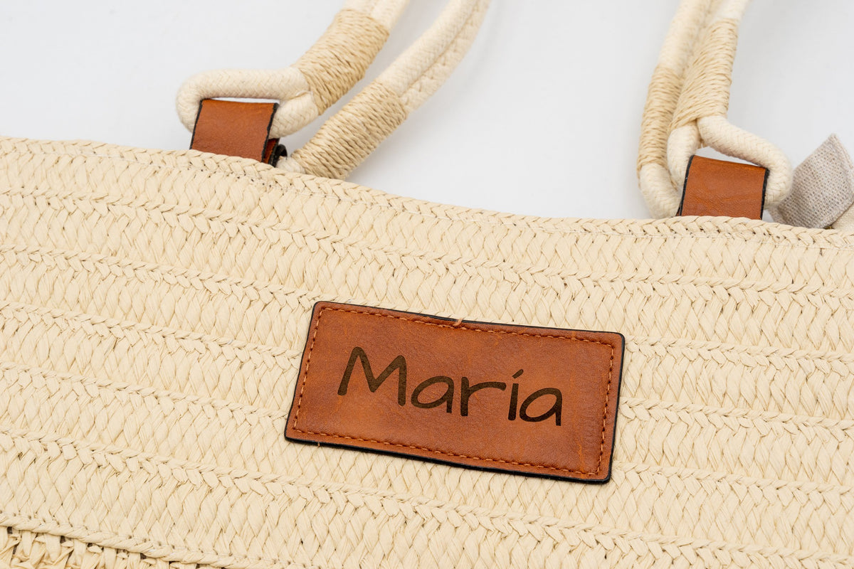 Patch an einer Tasche aus naturfarbenem Raffia, graviert mit dem Namen María