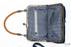 Interior de bolso con forro de rayas blancas y azules y bolsillo interno con cremallera.