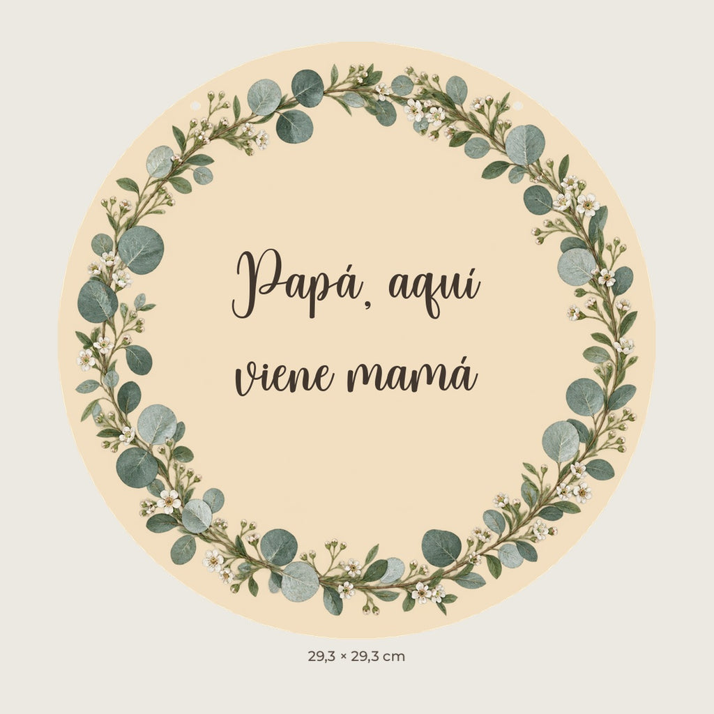 Digitale Vorschau: rundes Schild mit Eukalyptus und Blumen, dem Text „Papá, aquí viene mamá“ und zwei oberen Löchern.
