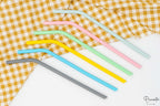Seis pajitas de silicona acodadas en colores variados sobre fondo blanco.