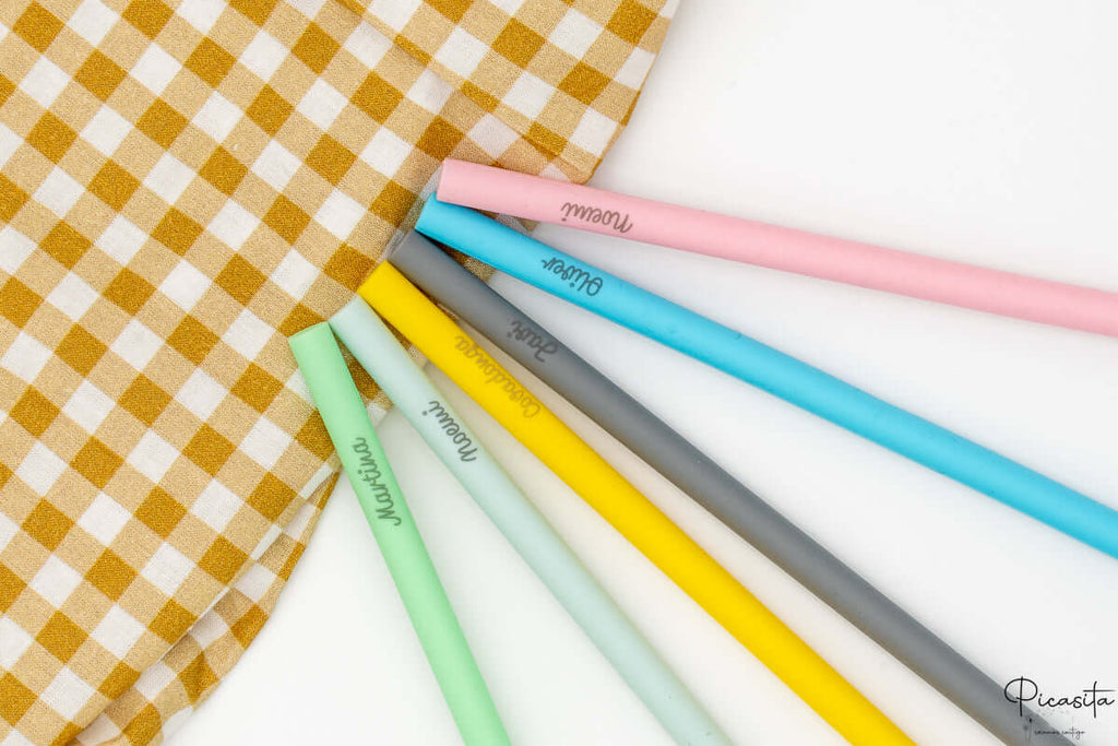 Primer plano de nombres personalizados grabados permanentemente en pajitas de colores.