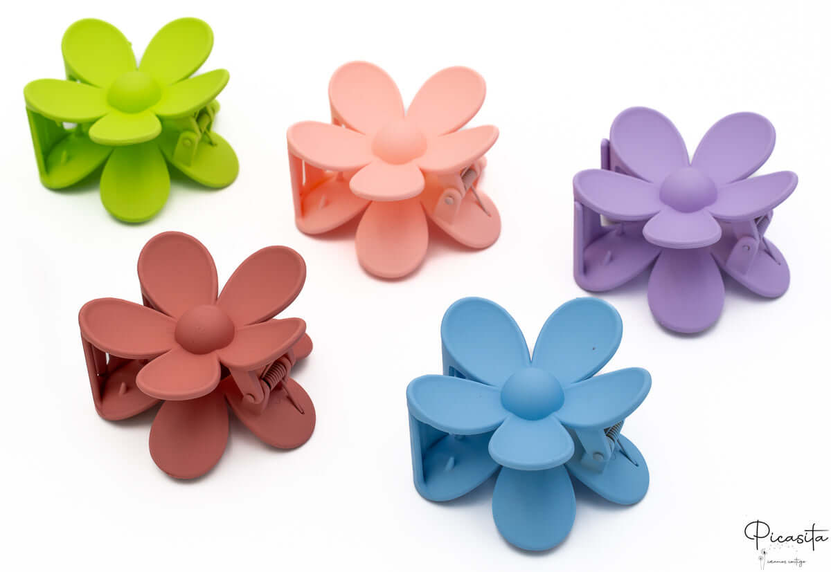 Pinzas de pelo tipo flor en tonos verde flúor, melocotón, lila, granate y azul suave.