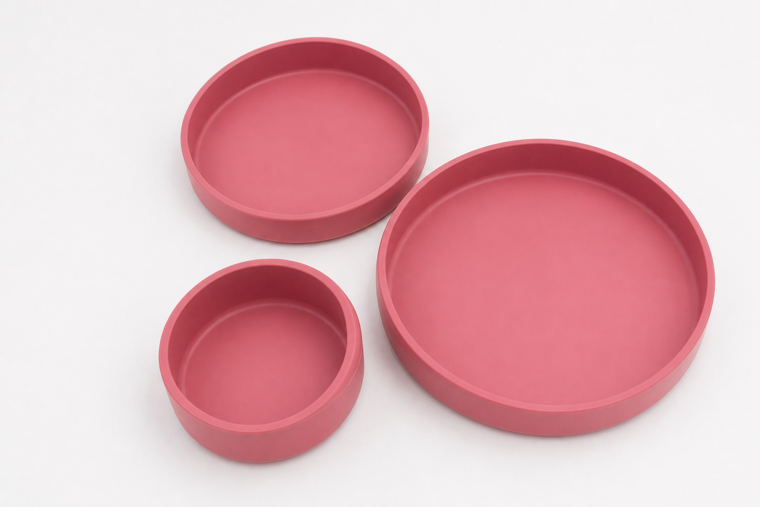 Juego de tres platos de silicona en color rosa oscuro, mostrados en sus tres tamaños