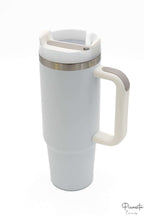 Vaso térmico color blanco con asa ergonómica y tapa con apertura para pajita.