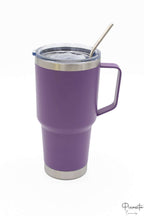 Vaso térmico color púrpura con asa y pajita metálica en tapa transparente.