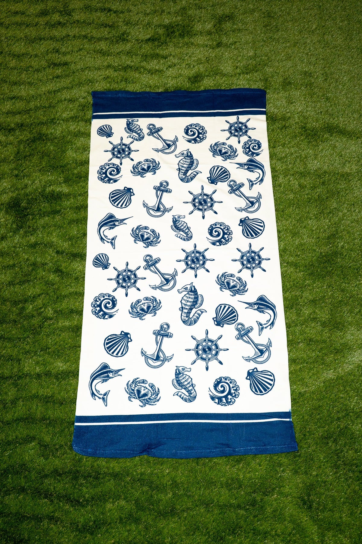 Weißes Handtuch mit blauem nautischem Muster aus Ankern, Muscheln und Steuerrädern