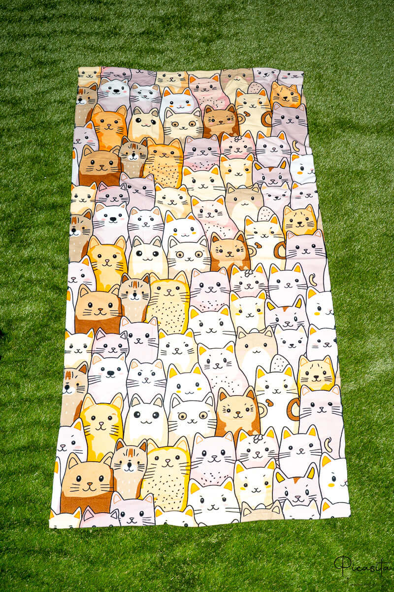 Toalla con diseño de gatos en tonos tierra, beige y blanco sobre fondo claro.